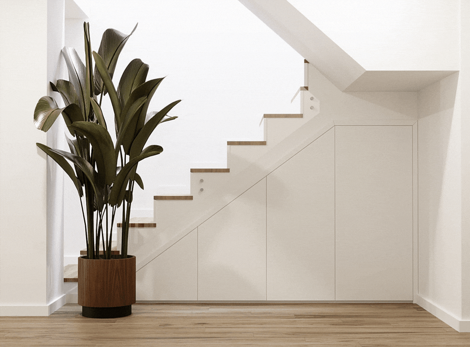 Solución de almacenaje bajo la escalera con armarios blancos empotrados y una planta alta decorativa.