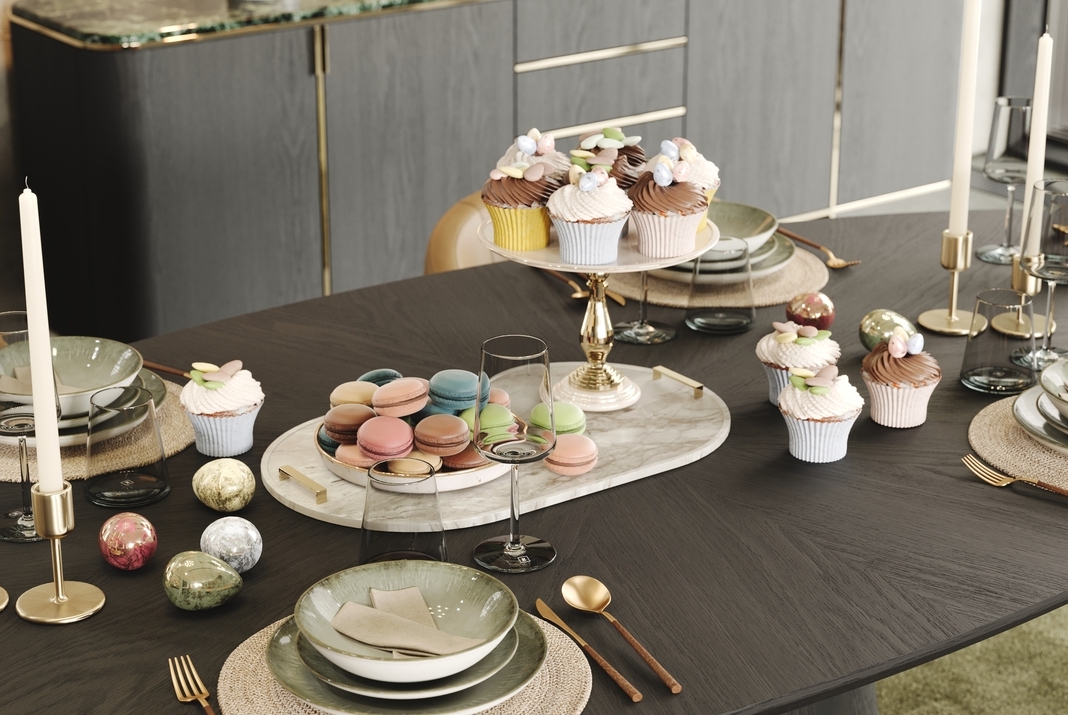 Dining table filled with easter cupcakes, macarons and easter eggs
