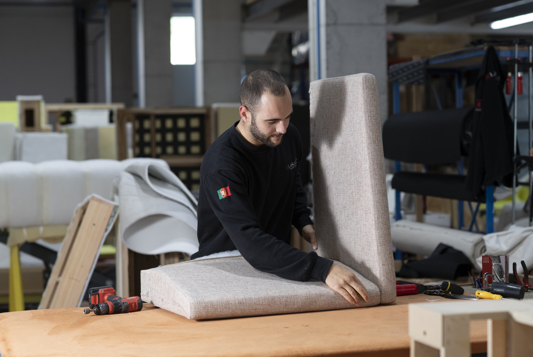 Crafstman in furniture factory assembling a furniture piece