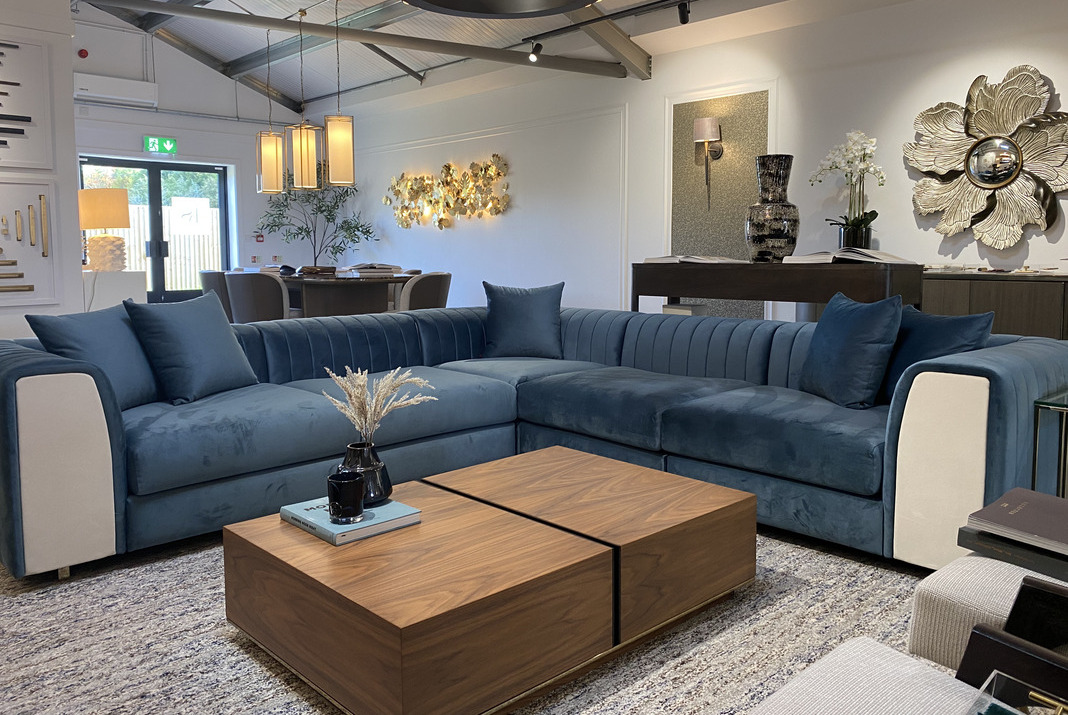 Showroom with a modular blue sofa and a coffee table book