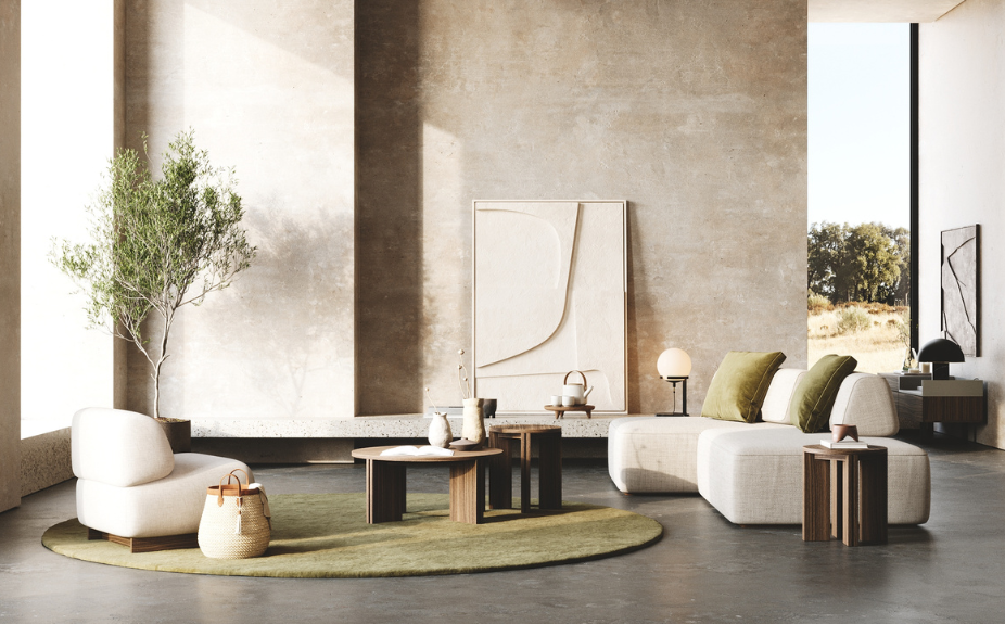 Salón con decoración en tonos naturales y terrosos: iluminación de ambiente creada por lámpara de mesa discreta y abundante luz natural