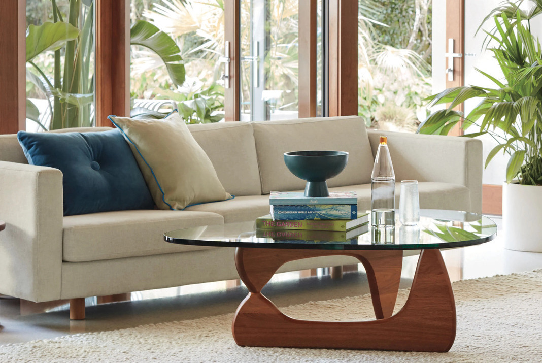 Noguchi coffee table and sofa in a living room with greenery