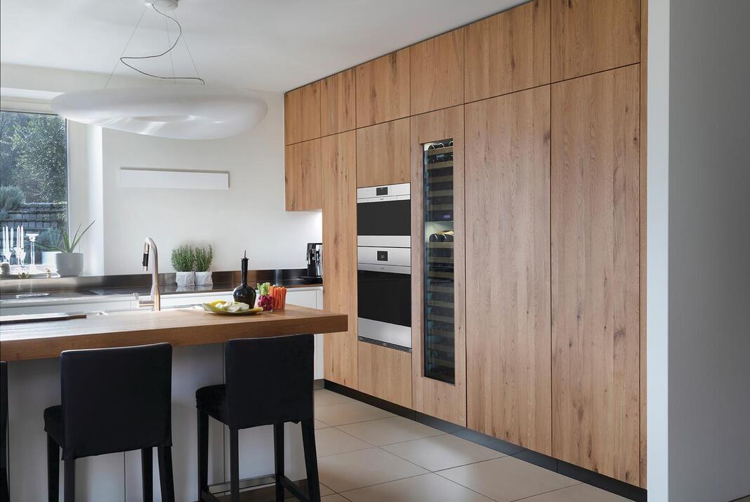 Kitchen with light wood floor to ceiling cabinets