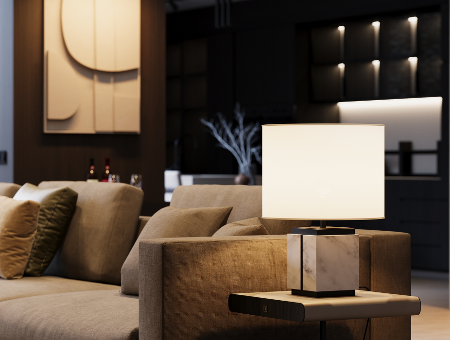 Tendências de decoração para outono e inverno de 2025 em sala de estar acolhedora com iluminação suave e algumas zonas mais intensas com o candeeiro ao lado do sofá e foco luminoso em quadro decorativo